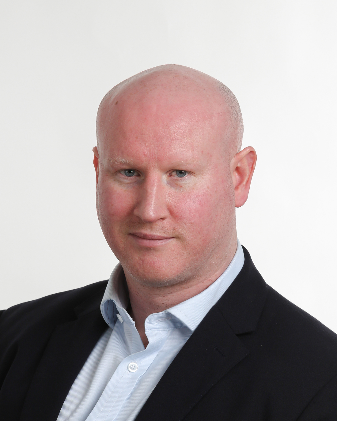 Browne Group - Bald man in a suit jacket and light blue shirt, looking at the camera with a neutral expression.