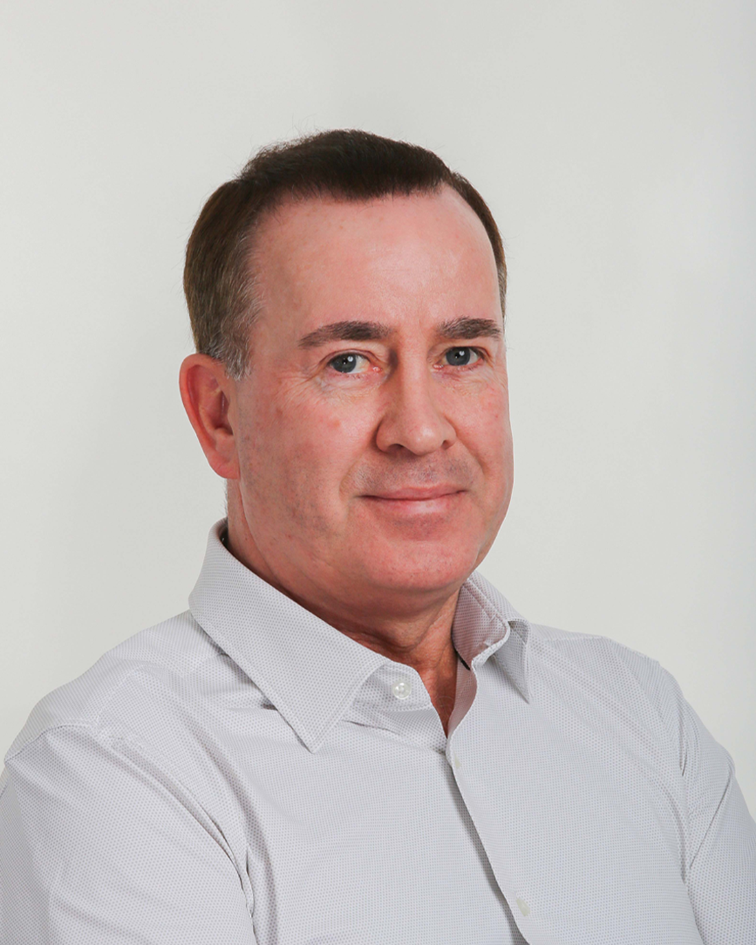 Browne Group - A middle-aged man with short dark hair, wearing a light-colored collared shirt, smiles at the camera.