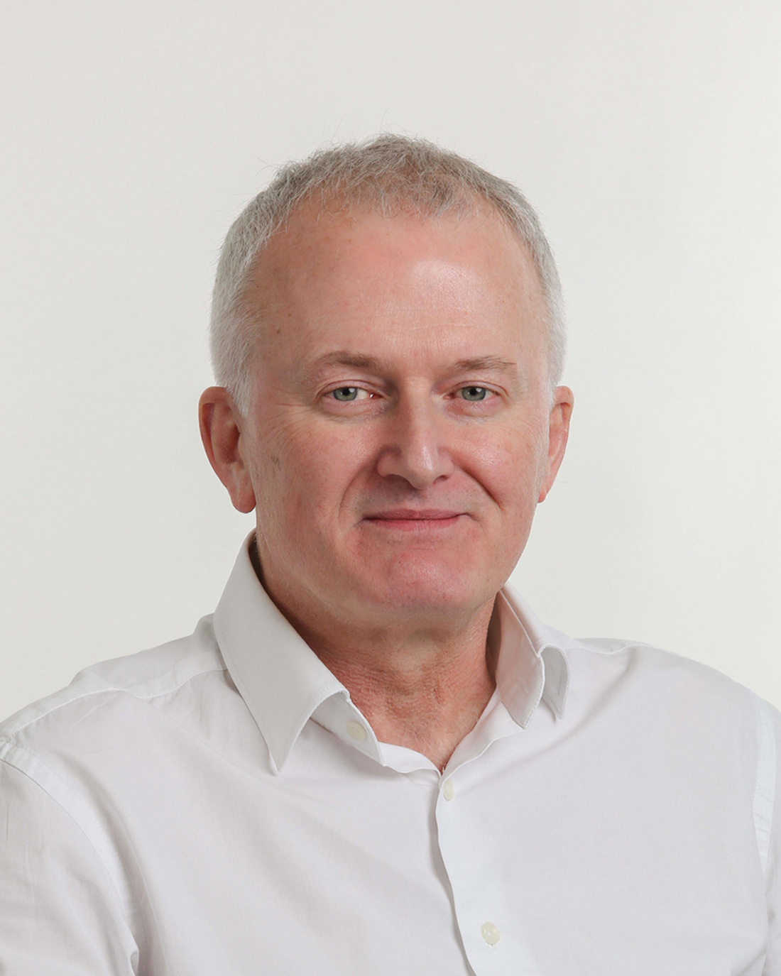 Browne Group - A middle-aged man with short gray hair, wearing a white shirt, smiling slightly against a plain background.