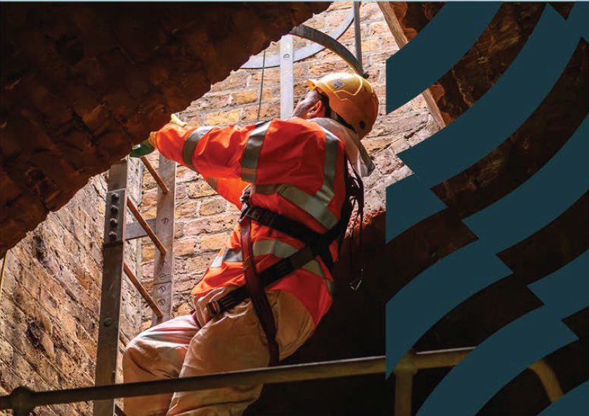 Browne Group - Worker in safety gear climbs a metal ladder inside a brick structure with sunlight overhead.